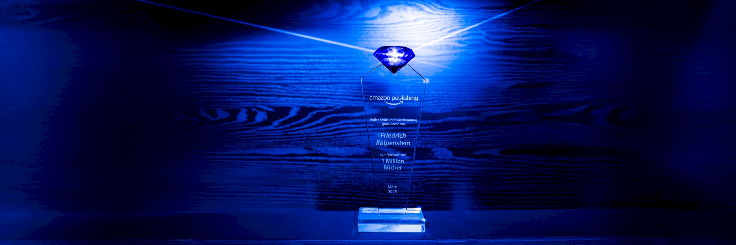 Zu sehen ist die Trophäe für eine Million verkaufte Bücher. Sie ist aus Glas und trägt einen blauen Diamanten, ebenfalls aus Glas.